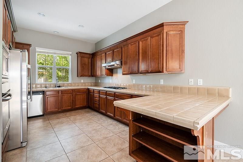 7677 Stone Bluff Way Reno, NV 89523 - Photo 5 of 17 a kitchen with a stove a sink and a refrigerator