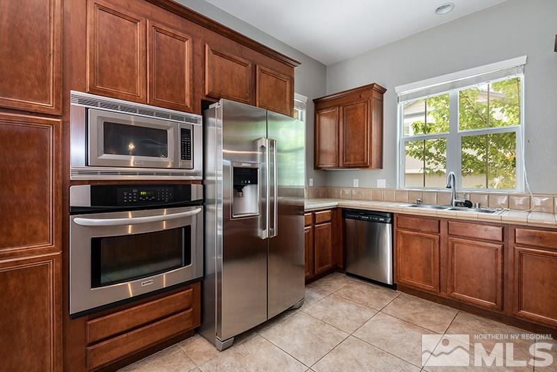 7677 Stone Bluff Way Reno, NV 89523 - Photo 6 of 17 a kitchen with granite countertop a stove top oven microwave and refrigerator
