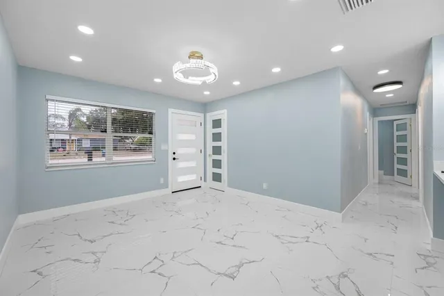 en empty room with windows and ceiling fan