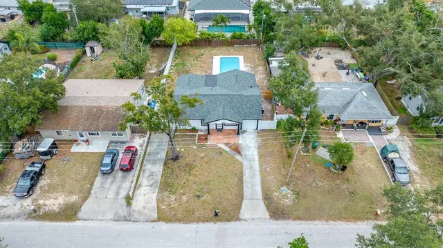 an aerial view of residential houses with outdoor space and trees
