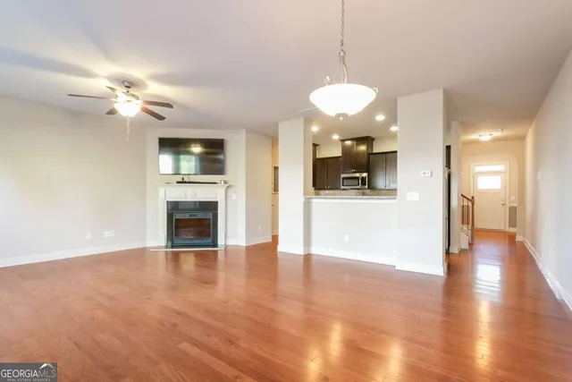 a view of a big room with wooden floor and a kitchen
