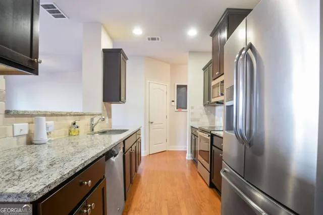 a kitchen with stainless steel appliances granite countertop a refrigerator and a sink