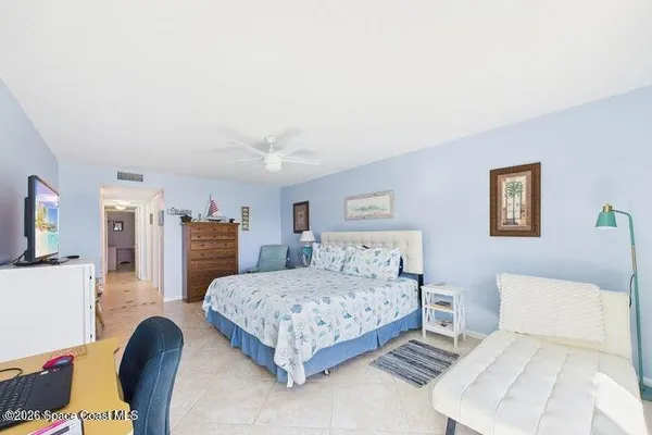 a bedroom with a balcony a large bed and a large window