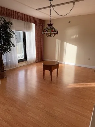 a view of a livingroom with a white furniture wooden floor and a ceiling fan