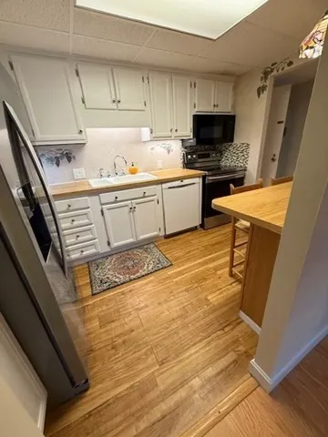 a kitchen with stainless steel appliances a stove a sink and a refrigerator