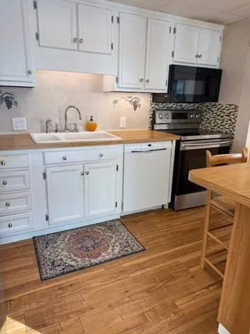a kitchen with stainless steel appliances granite countertop a sink stove and cabinets