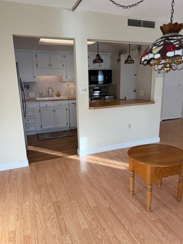 73 Broad Reach, Unit M36C Weymouth, MA 02191 - Photo 7 of 31 a room with wooden floor and white cabinets