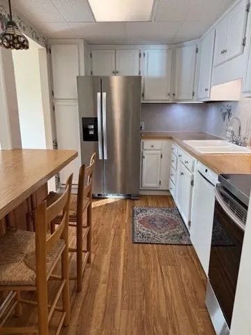 a kitchen with granite countertop a refrigerator stove and sink