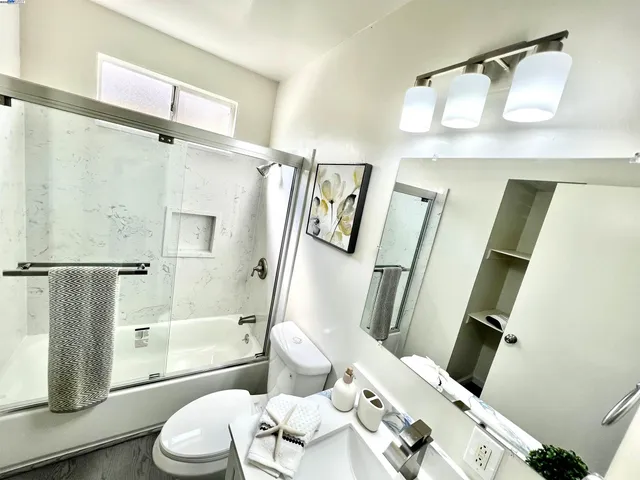 a bathroom with a sink mirror vanity and toilet