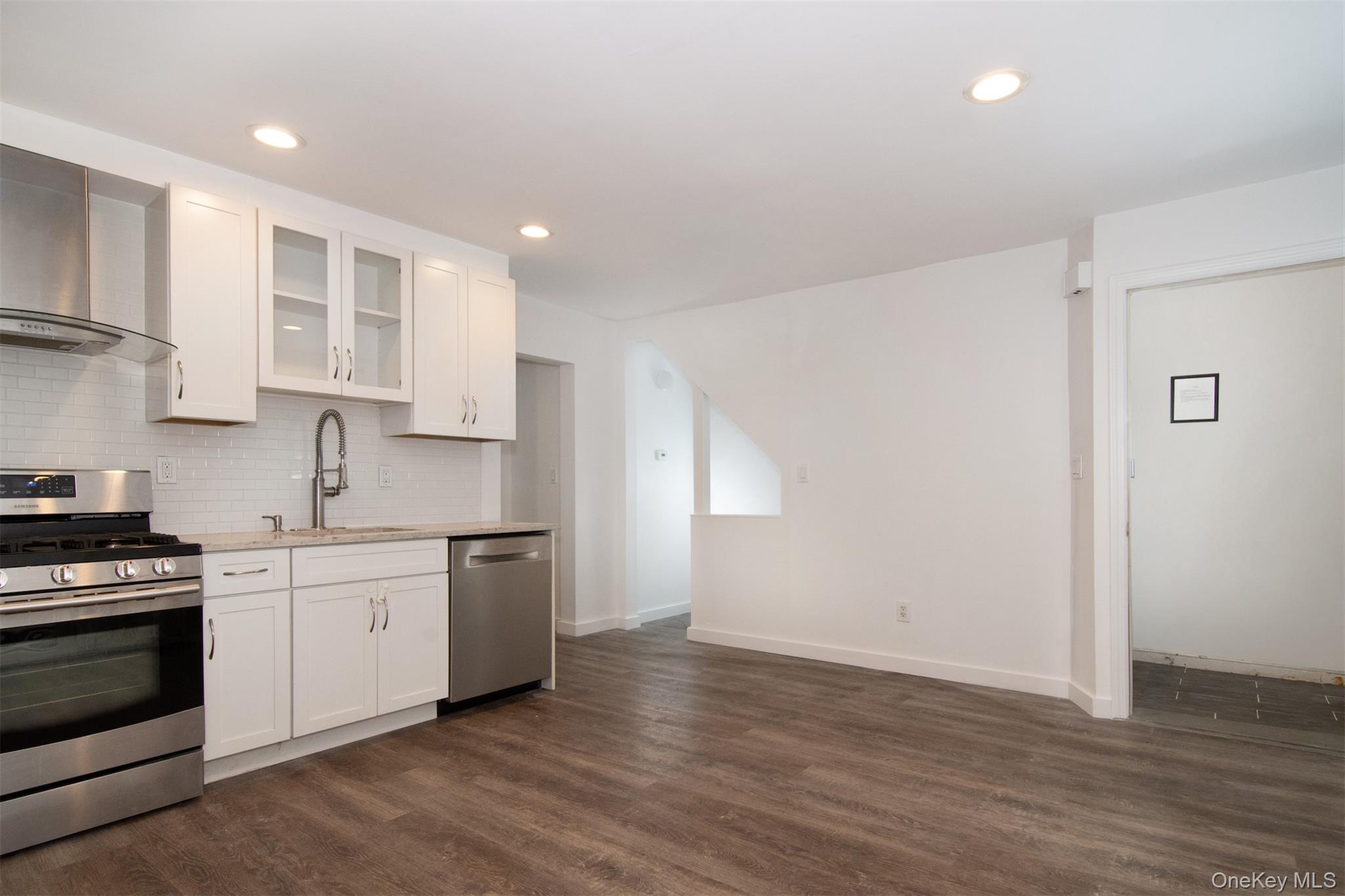 44 Ridge Street, Unit 1 Hastings-on-Hudson, NY 10706 - Photo 4 of 16 Kitchen with stainless steel appliances, dark hardwood / wood-style flooring, white cabinetry, and sink