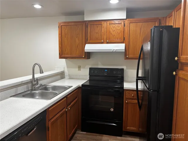 a kitchen with stainless steel appliances granite countertop a refrigerator and a sink