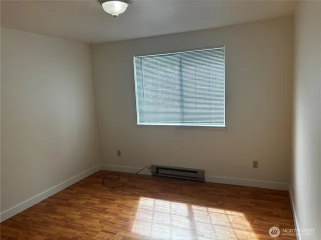 a view of a room with wooden floor and windows