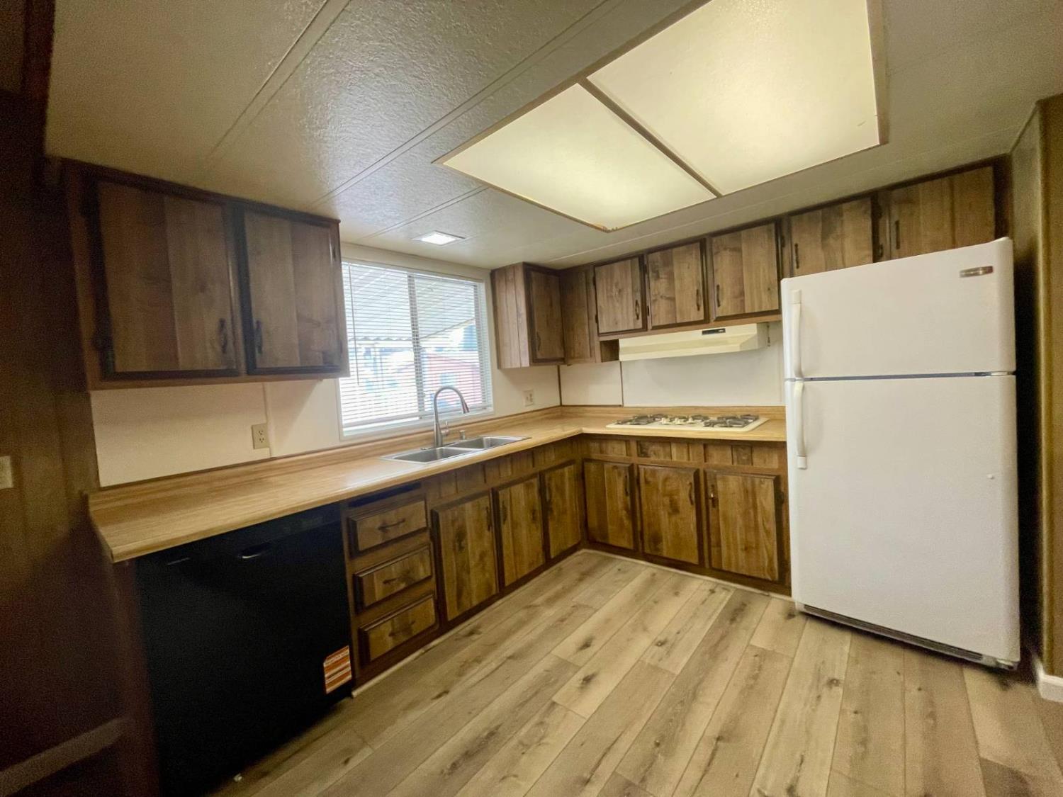 3901 Lake Road, Unit 111 West Sacramento, CA 95691 - Photo 10 of 16 a kitchen with wooden cabinets and white appliances