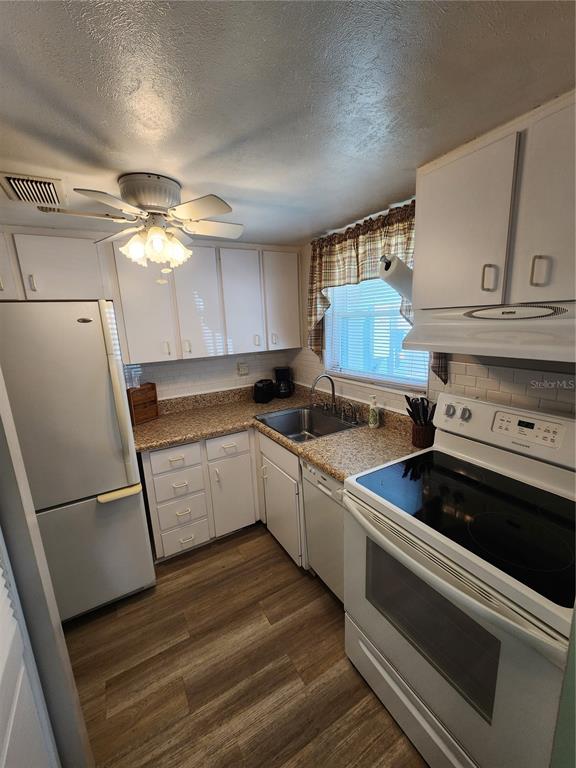 5842 Welcome Road, Unit J2 Bradenton, FL 34207 - Photo 12 of 25 a kitchen with a stove and white cabinets