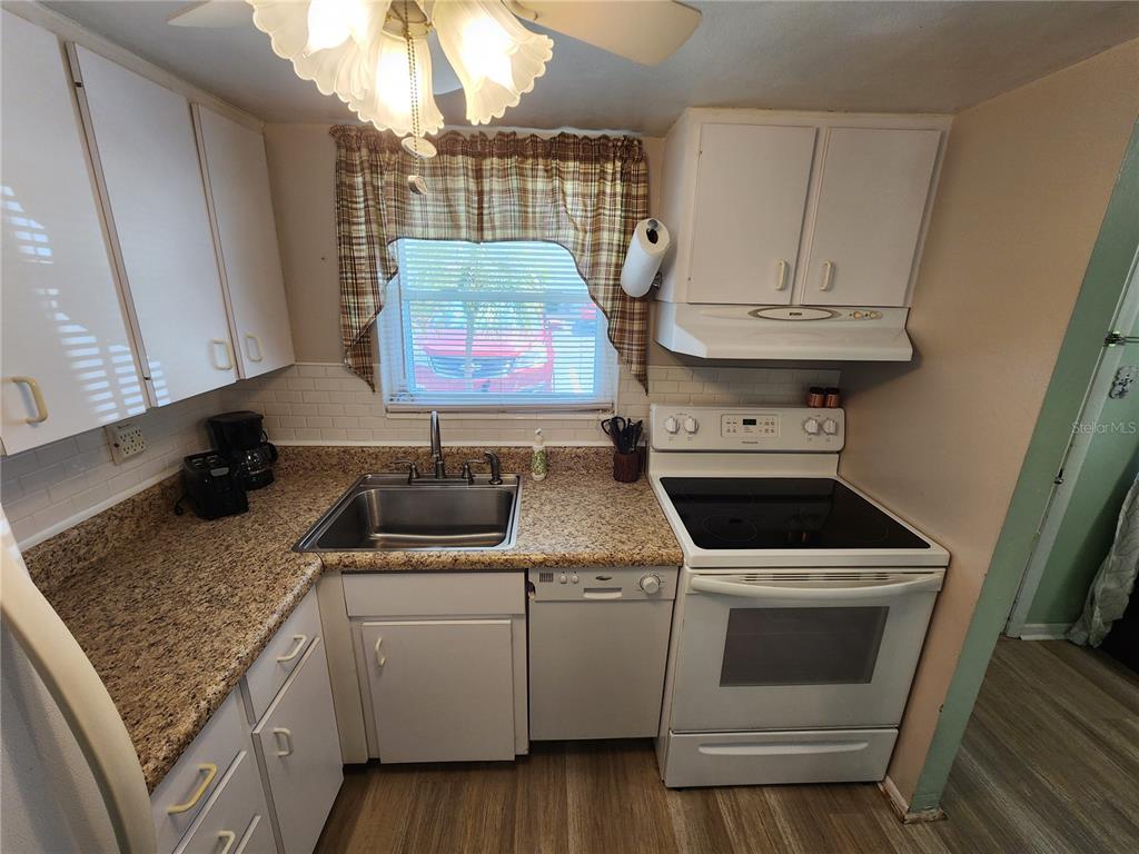 5842 Welcome Road, Unit J2 Bradenton, FL 34207 - Photo 9 of 25 a kitchen with stainless steel appliances granite countertop a stove a sink and a microwave