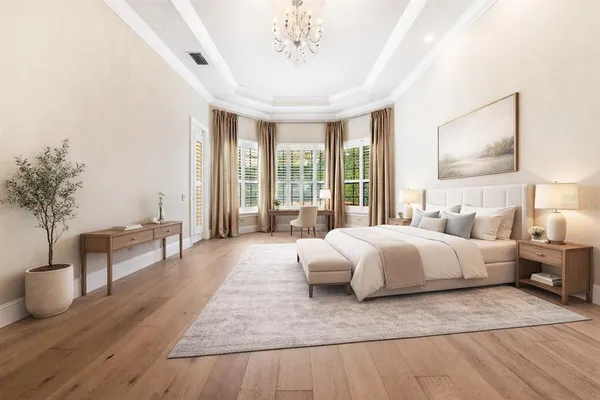 a spacious bedroom with a large bed and a chandelier