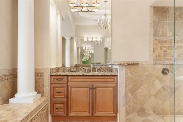 a bathroom with a granite countertop shower a mirror and a sink