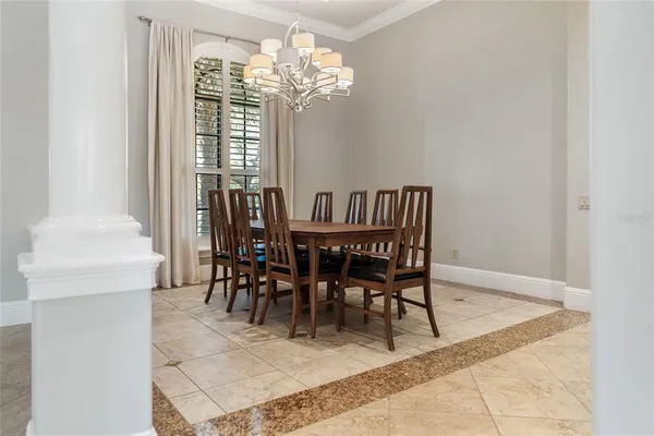 a dining room with furniture a chandelier and window