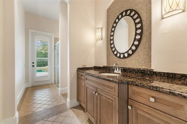 a bathroom with a granite countertop sink and a mirror