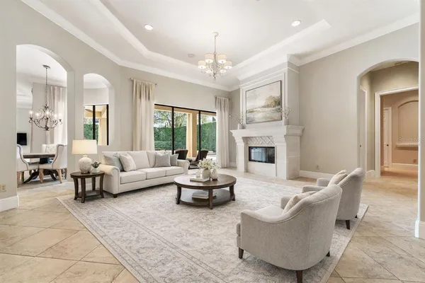 a living room with furniture fireplace and large windows