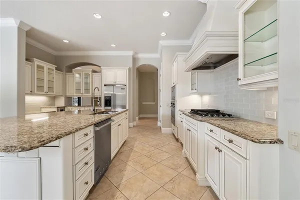a large kitchen with stainless steel appliances granite countertop a lot of counter space and a sink