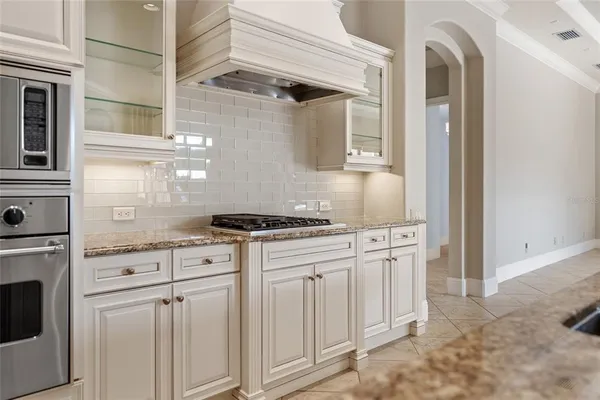 a kitchen with stainless steel appliances granite countertop white cabinets and white appliances