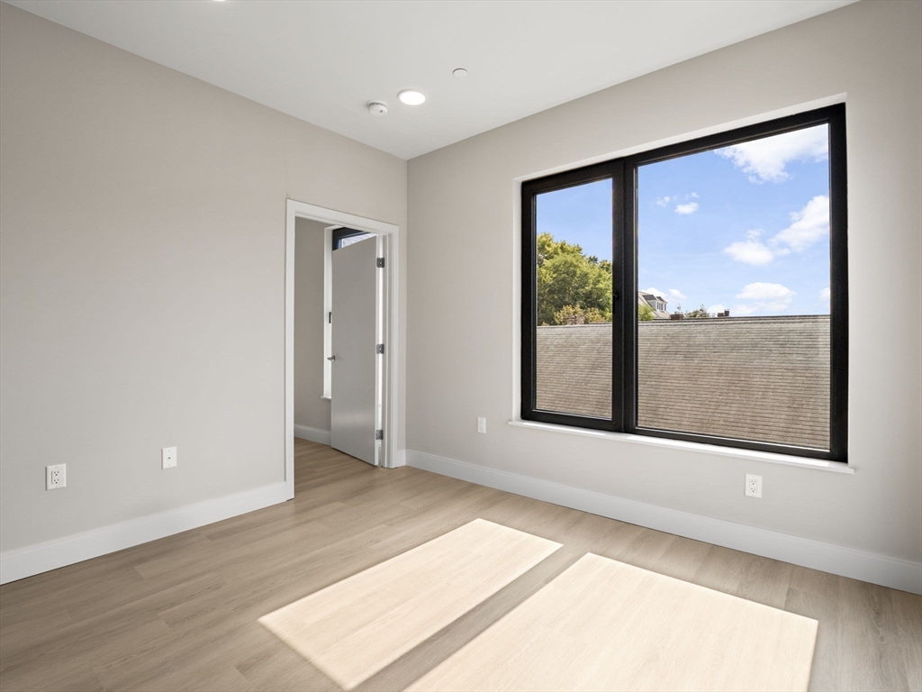 249 Corey Road, Unit 401 Boston, MA 02135 - Photo 15 of 34 a view of an empty room with a window and a floor to ceiling window