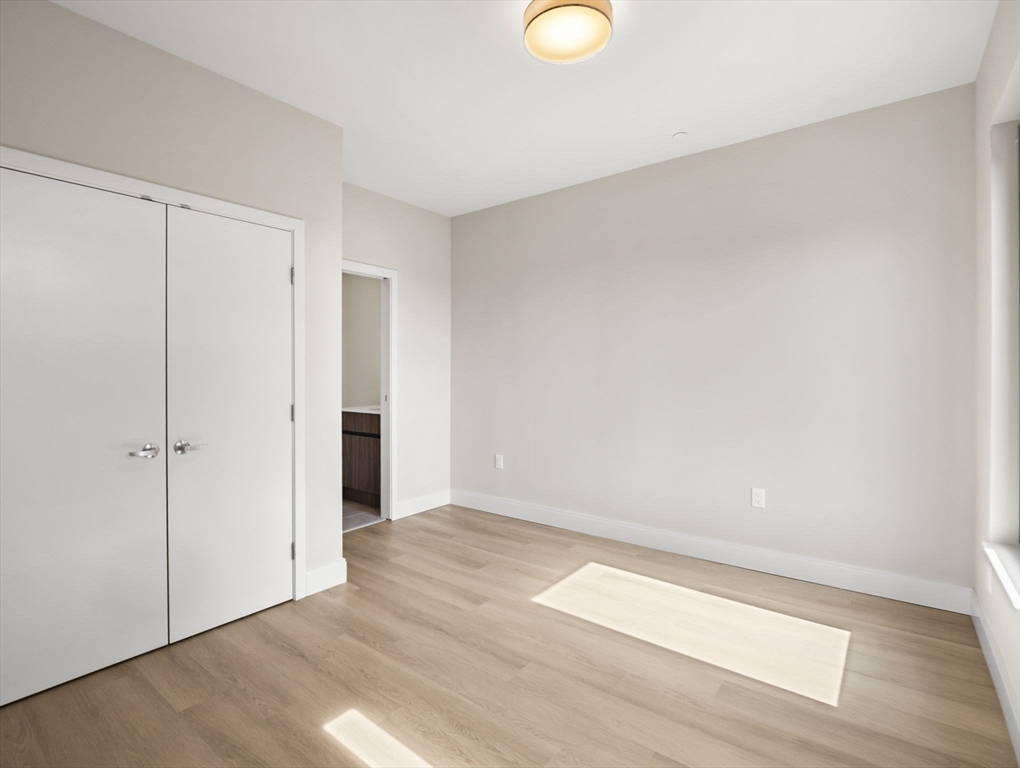 249 Corey Road, Unit 401 Boston, MA 02135 - Photo 16 of 34 a view of an empty room with wooden floor