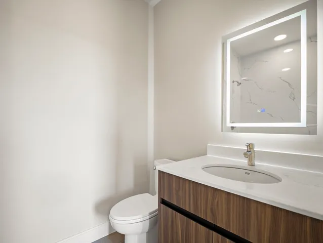 a bathroom with a sink a toilet and a mirror