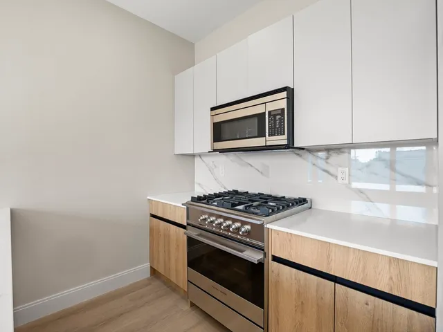 a kitchen with granite countertop cabinets stainless steel appliances and wooden floor