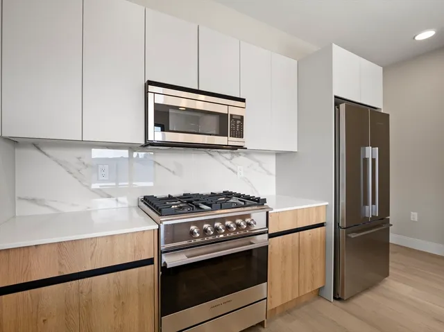 a kitchen with stainless steel appliances granite countertop a stove microwave and refrigerator
