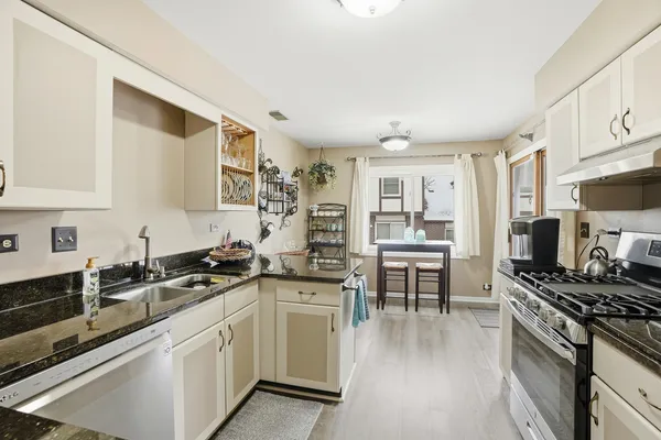 a kitchen with stainless steel appliances a stove sink and cabinets
