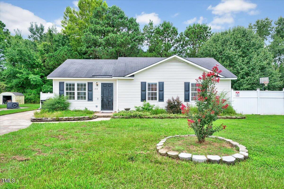 a front view of a house with a yard and trees