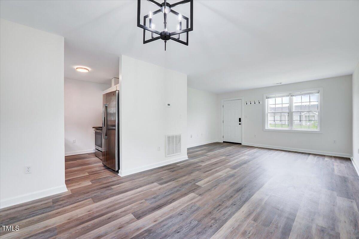 216 Katie Drive Rocky Mount, NC 27803 - Photo 11 of 27 a view of an empty room with wooden floor and a window