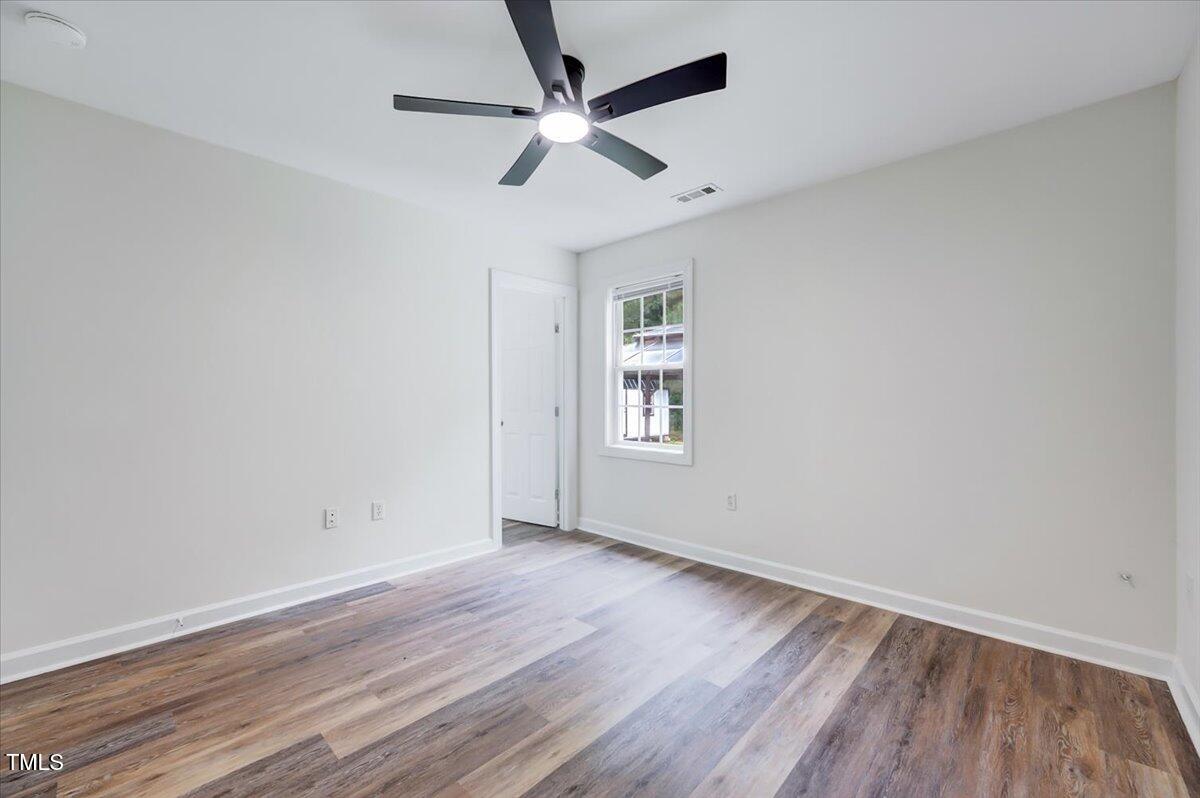 216 Katie Drive Rocky Mount, NC 27803 - Photo 25 of 27 an empty room with wooden floor ceiling fan and windows