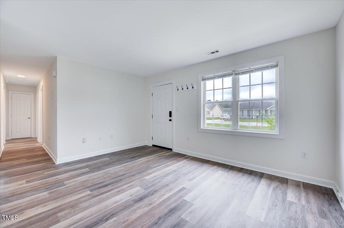 216 Katie Drive Rocky Mount, NC 27803 - Photo 6 of 27 an empty room with wooden floor and windows