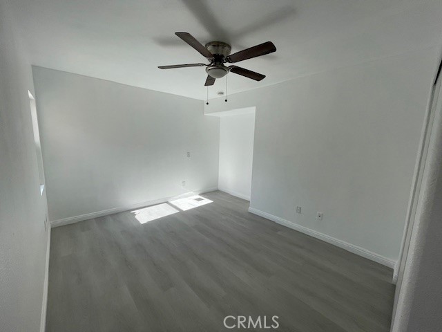 15721 Lakeridge Road, Unit ADU Lake Elsinore, CA 92530 - Photo 14 of 22 an empty room with wooden floor and ceiling fan