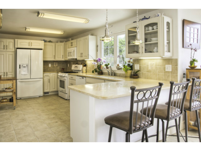 3481 Oliver Road Carmel, CA 93923 - Photo 4 of 18 a kitchen with stainless steel appliances granite countertop a table chairs and a refrigerator