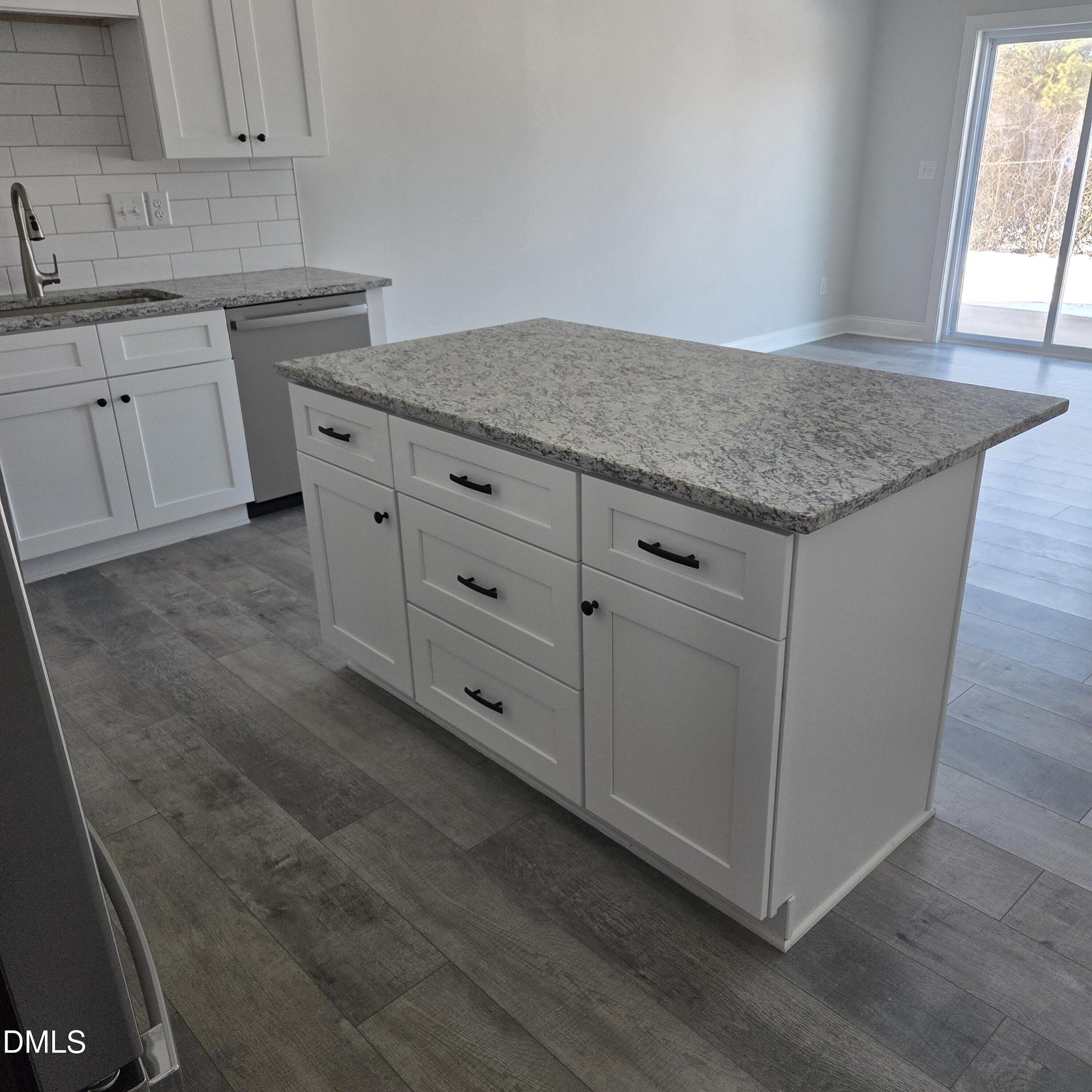 249 North Hickory Street Angier, NC 27501 - Photo 2 of 4 a kitchen with granite countertop white cabinets and white appliances
