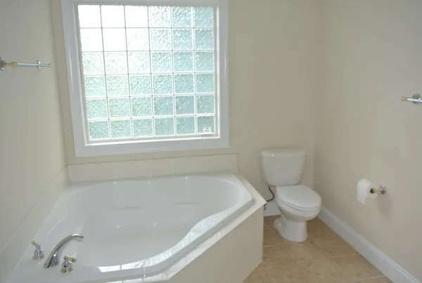 a white toilet sitting next to a bath tub
