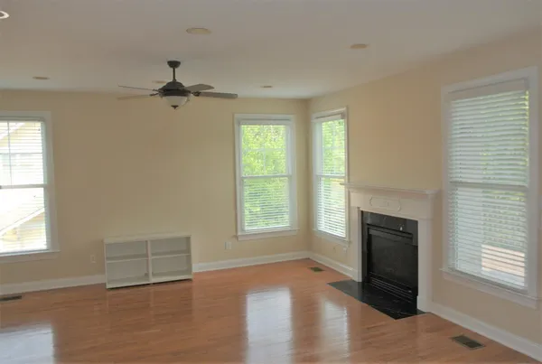an empty room with windows and fireplace