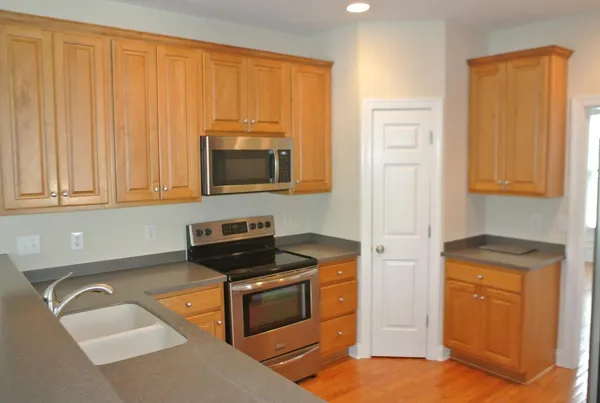a kitchen with stainless steel appliances granite countertop a stove a sink and a microwave