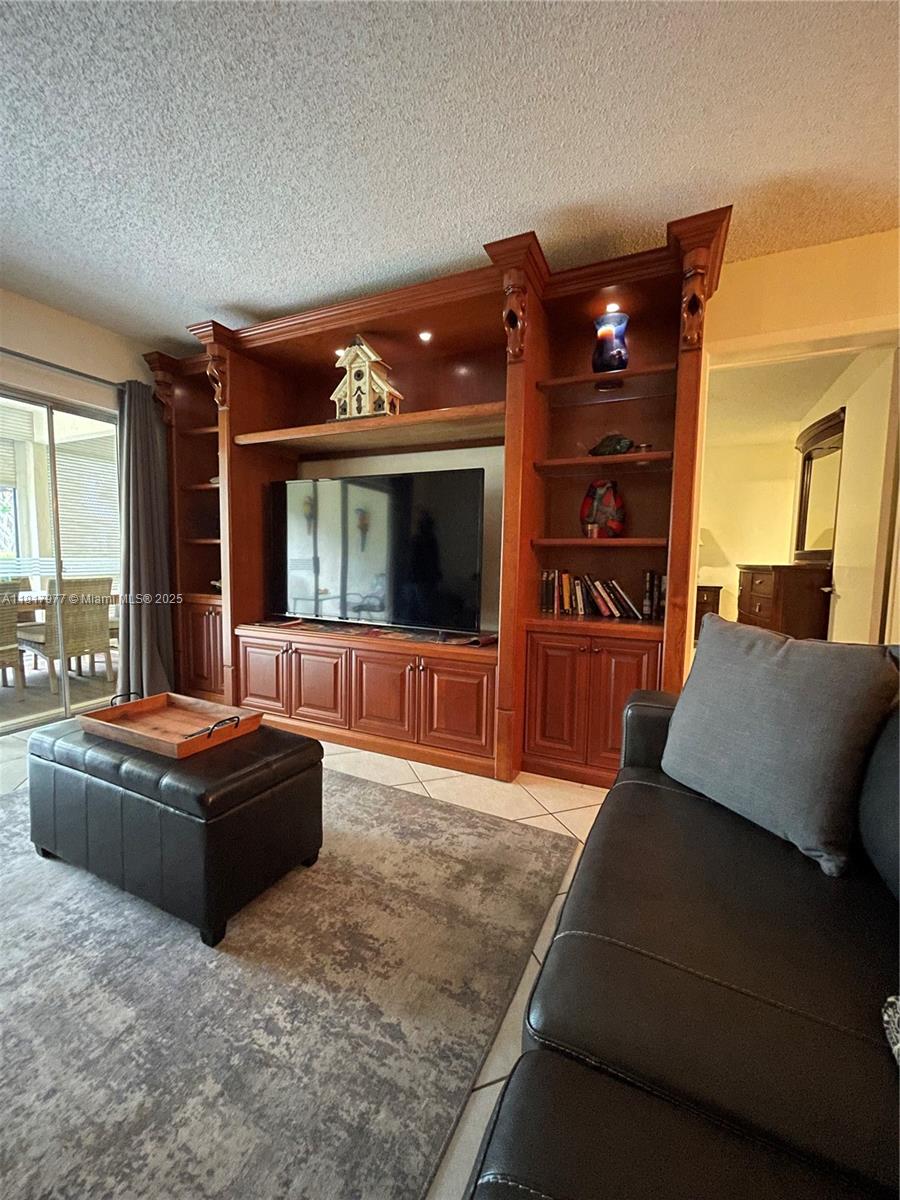 4000 Crystal Lake Drive, Unit 111 Deerfield Beach, FL 33064 - Photo 11 of 26 a living room with furniture and a flat screen tv