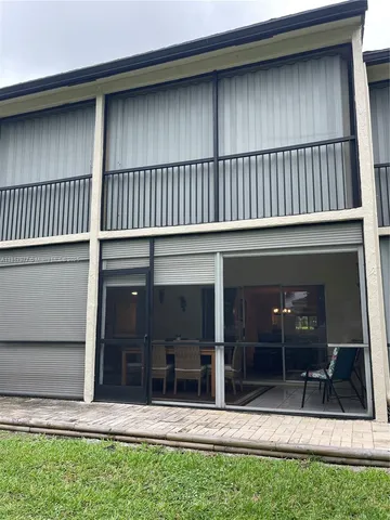 a view of a house with a large window and plants