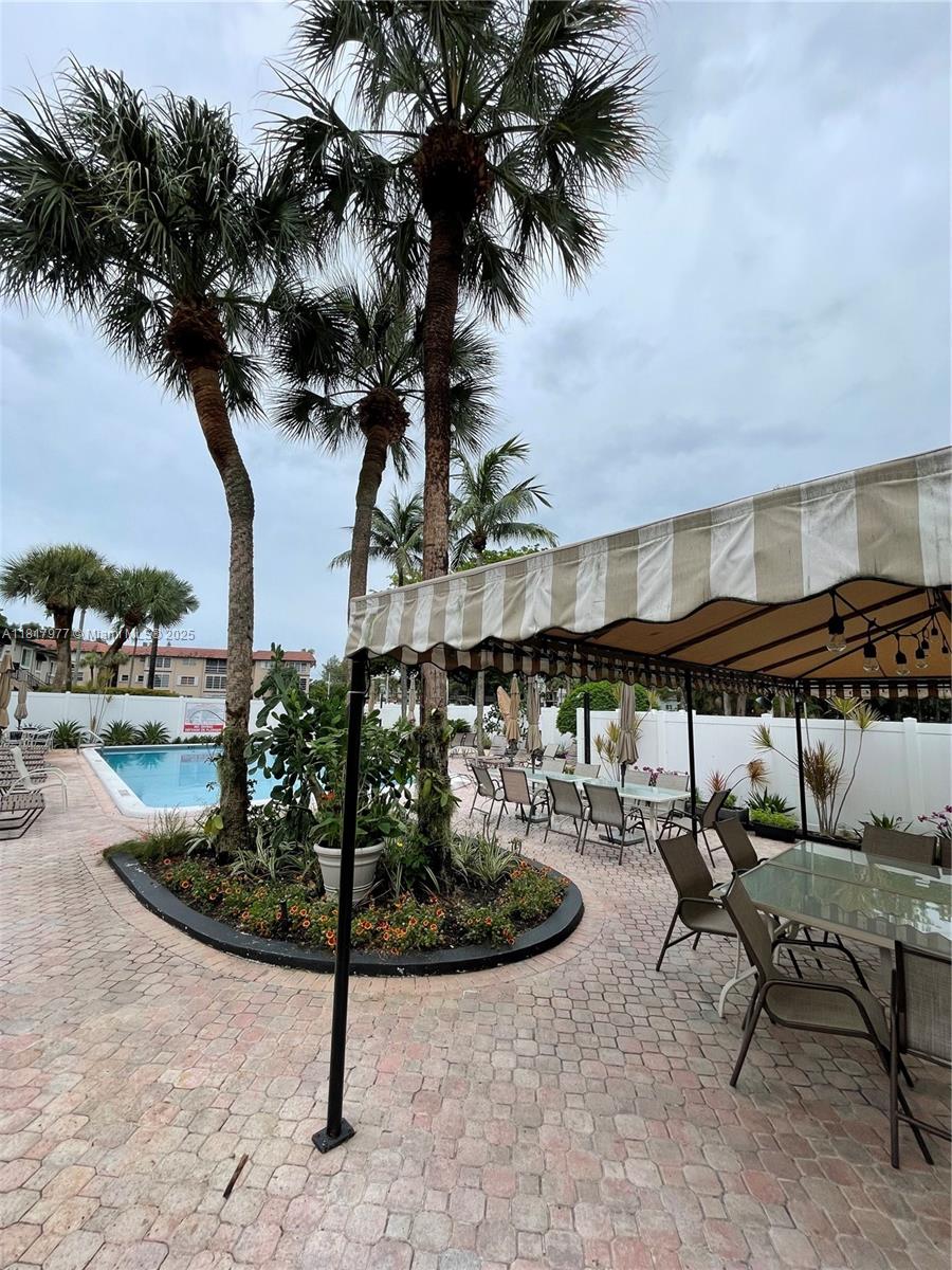 4000 Crystal Lake Drive, Unit 111 Deerfield Beach, FL 33064 - Photo 25 of 26 a front view of a house with garden and sitting area