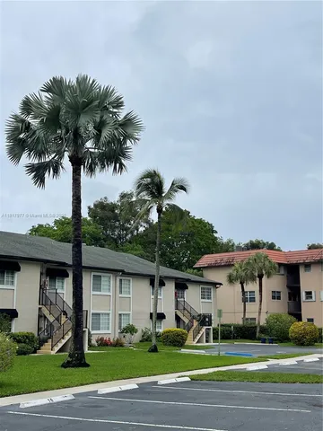 a front view of a house with a yard and potted plants