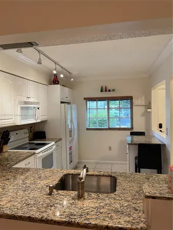 a kitchen with kitchen island granite countertop a sink and counter space