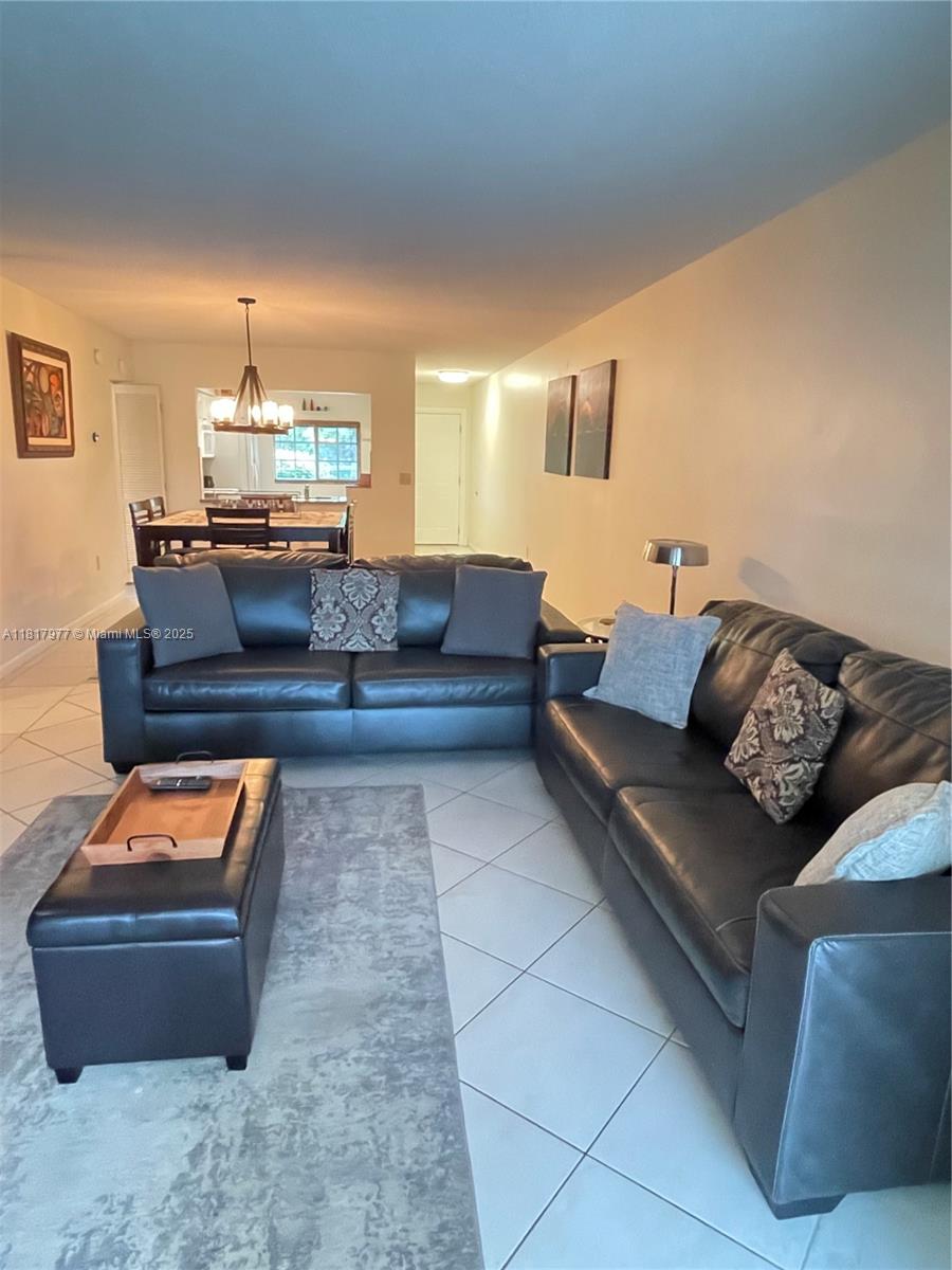 4000 Crystal Lake Drive, Unit 111 Deerfield Beach, FL 33064 - Photo 9 of 26 a living room with furniture and a chandelier