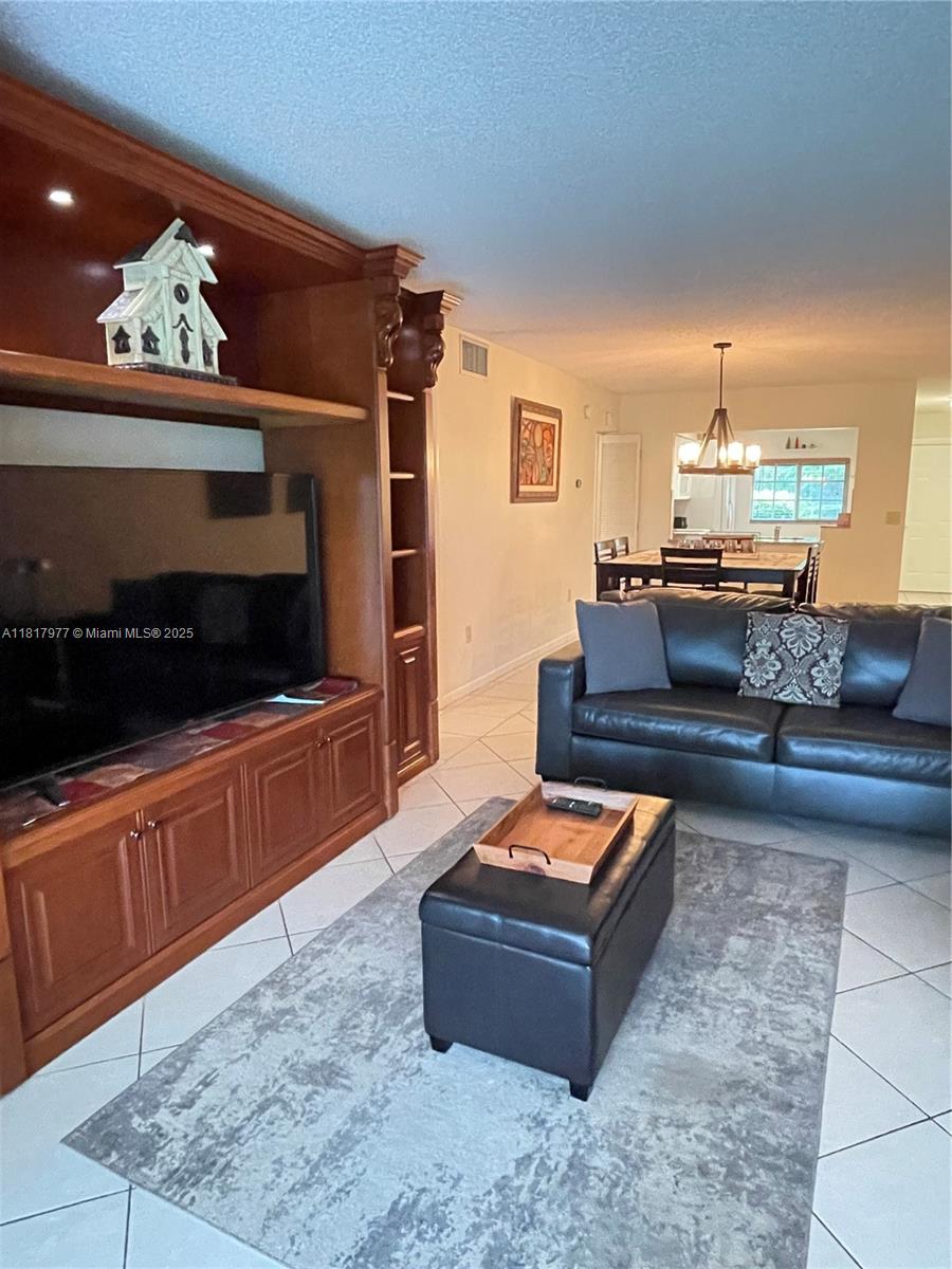 4000 Crystal Lake Drive, Unit 111 Deerfield Beach, FL 33064 - Photo 10 of 26 a living room with furniture and a wooden floor