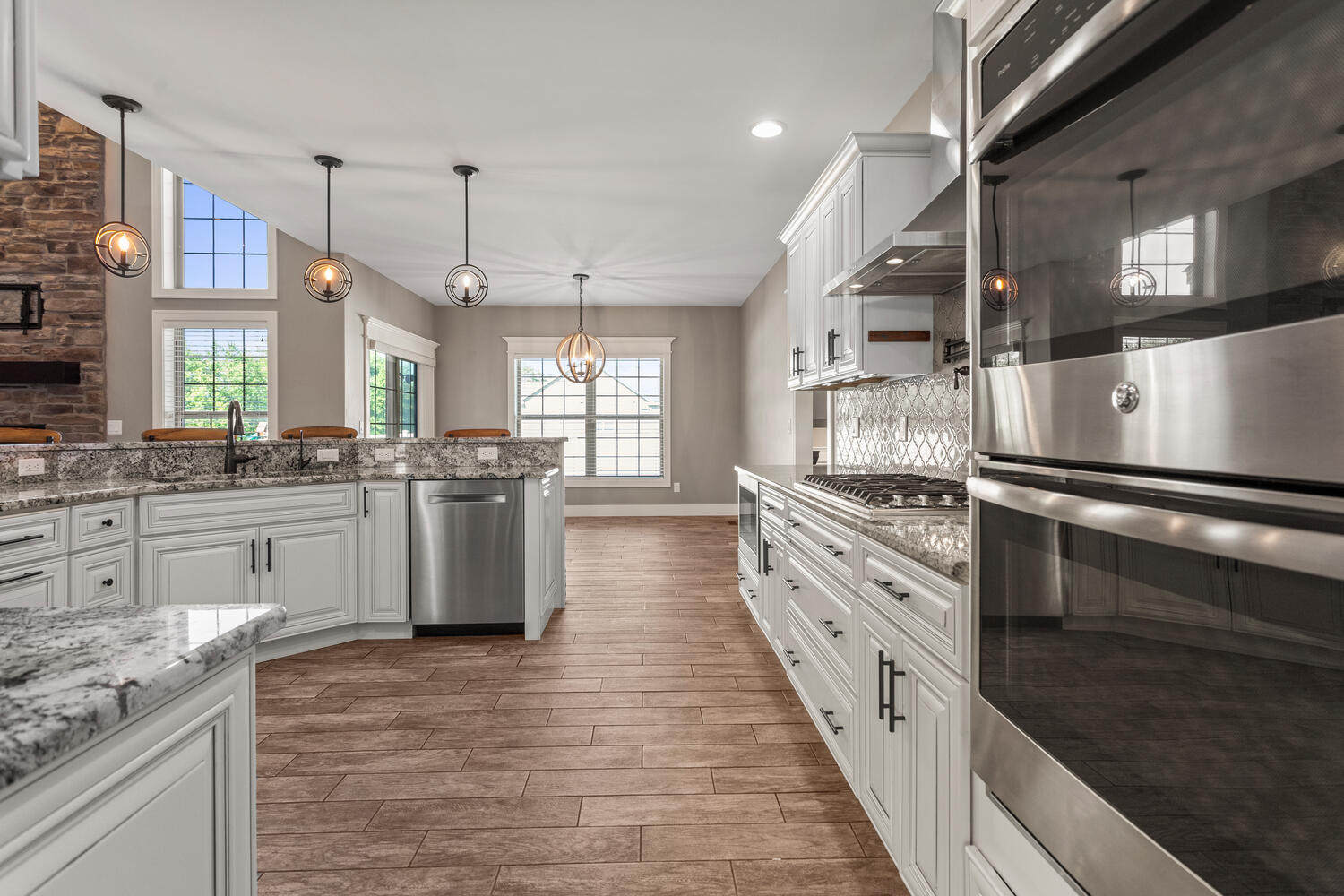 1101 Cascade Drive Savoy, IL 61874 - Photo 15 of 55 a large kitchen with stainless steel appliances kitchen island granite countertop a stove and a sink